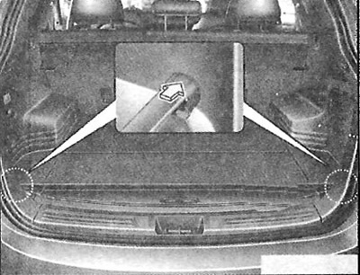 Для использования защитного багажного экрана потяните рукоятку назад и вставьте края в гнезда.